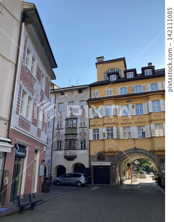 Narrow old town street with traditional arcade arches and colorful facades in Europe Narrow old town street with traditional arcade arches and colorful facades in Europe 142111085