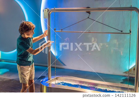 Older boy exploring interactive science exhibit with giant bubbles at museum, hands-on STEM learning, curiosity, experiment and playful education concept Older boy exploring interactive science exhibit with giant bubbles at museum, hands-on STEM learning, curiosity, experiment and playful education concept 142111126