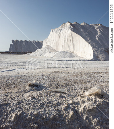 Massive white salt mounds at a salt production site under bright daylight Massive white salt mounds at a salt production site under bright daylight 142111203