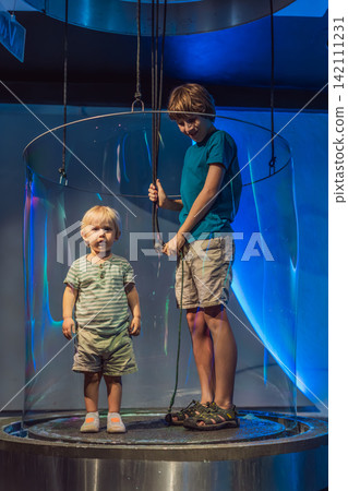 Young boys use hands-on exhibits with water and giant bubbles, showing STEM learning, curiosity and playful science education concept Young boys use hands-on exhibits with water and giant bubbles, showing STEM learning, curiosity and playful science education concept 142111231
