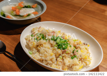 Fried rice and soup on a wooden table Fried rice and soup on a wooden table 142111422