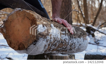 Male hand sawing a log in sunny winter forest. Strong guy working with a saw in snowy woodland. Concept of strength, masculine, energy, and harmony with nature during cold season. Slow motion Male hand sawing a log in sunny winter forest. Strong guy working with a saw in snowy woodland. Concept of strength, masculine, energy, and harmony with nature during cold season. Slow motion 142112048