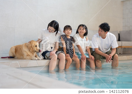 A family playing with their dog in the pool A family playing with their dog in the pool 142112076