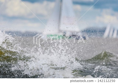 magic splashing water, Russia, St.Petersburg, Yachtsmen are sitting amicably on board of the sailing boat in sailing regatta in the Gulf of Finland at sunny day, teamwork magic splashing water, Russia, St.Petersburg, Yachtsmen are sitting amicably on board of the sailing boat in sailing regatta in the Gulf of Finland at sunny day, teamwork 142112250