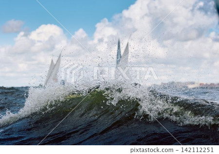 magic splashing water, Russia, St.Petersburg, Yachtsmen are sitting amicably on board of the sailing boat in sailing regatta in the Gulf of Finland at sunny day, teamwork magic splashing water, Russia, St.Petersburg, Yachtsmen are sitting amicably on board of the sailing boat in sailing regatta in the Gulf of Finland at sunny day, teamwork 142112251