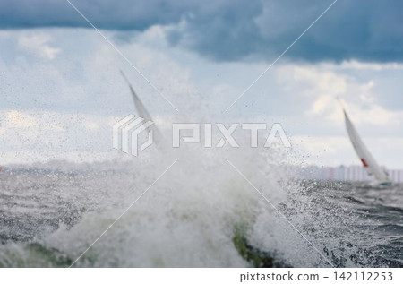 magic splashing water, Russia, St.Petersburg, Yachtsmen are sitting amicably on board of the sailing boat in sailing regatta in the Gulf of Finland at sunny day, teamwork magic splashing water, Russia, St.Petersburg, Yachtsmen are sitting amicably on board of the sailing boat in sailing regatta in the Gulf of Finland at sunny day, teamwork 142112253