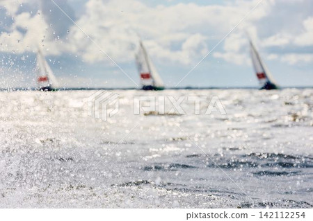 magic splashing water, Russia, St.Petersburg, Yachtsmen are sitting amicably on board of the sailing boat in sailing regatta in the Gulf of Finland at sunny day, teamwork magic splashing water, Russia, St.Petersburg, Yachtsmen are sitting amicably on board of the sailing boat in sailing regatta in the Gulf of Finland at sunny day, teamwork 142112254