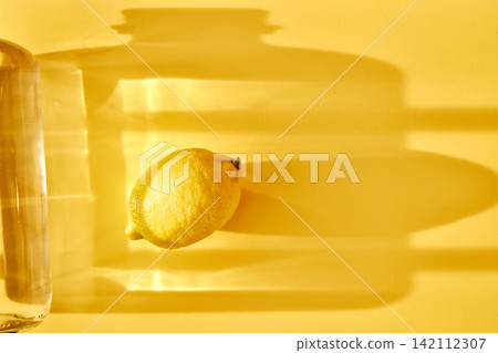 Lemon and refreshing drinking water on yellow background Lemon and refreshing drinking water on yellow background 142112307