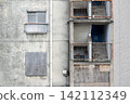 A dilapidated concrete apartment complex that has become a ruin. 142112349
