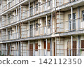 A dilapidated concrete apartment complex that has become a ruin. 142112350