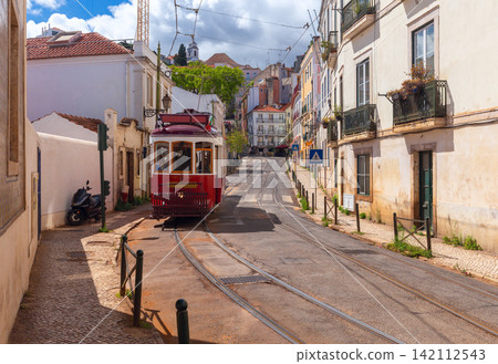 Traditional Red Tram on Historic Street in Lisbon, Portugal 142112543