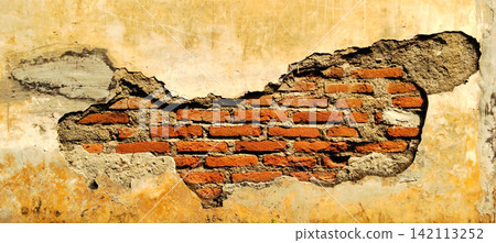 Damaged yellow plastered wall with exposed red brick texture. Damaged yellow plastered wall with exposed red brick texture. 142113252