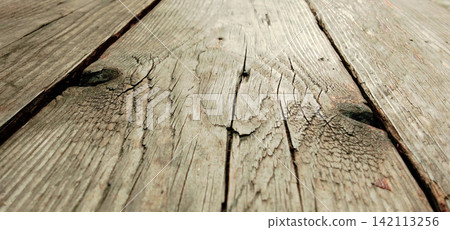 Weathered wooden floorboards, with cracks and grain texture. Weathered wooden floorboards, with cracks and grain texture. 142113256