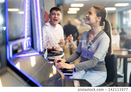 Girl is playing slot machines in casino Girl is playing slot machines in casino 142113977