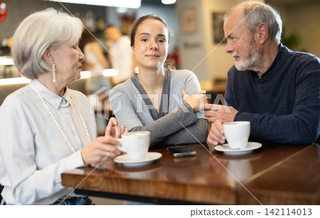 Young woman interacting with the older generation in a cafe Young woman interacting with the older generation in a cafe 142114013