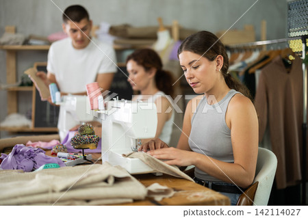 Young girl working with sewing-machine during dressmaking courses 142114027