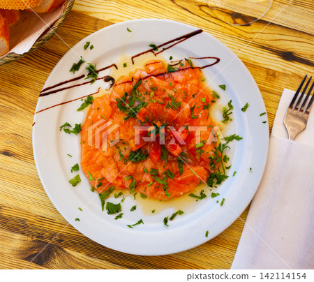 Image of salmon carpaccio served with greens on plate Image of salmon carpaccio served with greens on plate 142114154