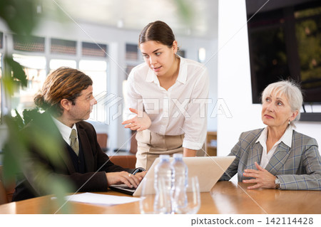 Business partners discussing documents and ideas at meeting Business partners discussing documents and ideas at meeting 142114428