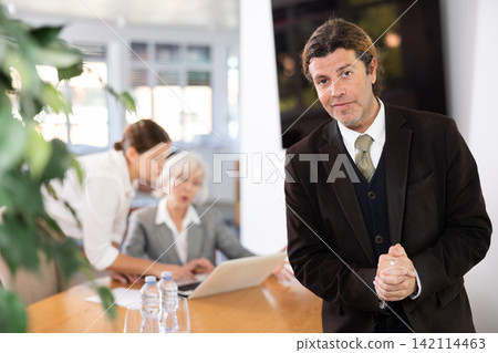 Interested adult businessman in formal suit inviting to office Interested adult businessman in formal suit inviting to office 142114463