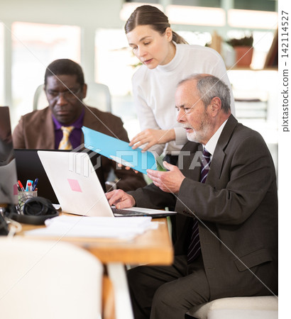 Employees work together in the office, they discuss everyday issues Employees work together in the office, they discuss everyday issues 142114527