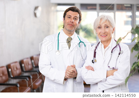 Two experienced professional doctors standing in medical office Two experienced professional doctors standing in medical office 142114550