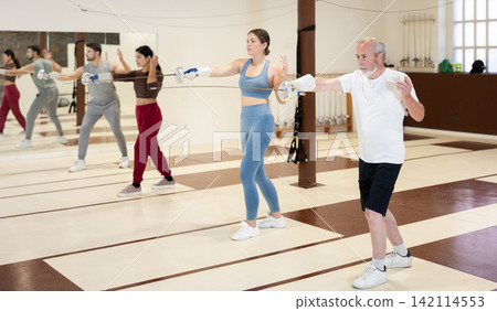 Group of fencers practicing sword movements in gym Group of fencers practicing sword movements in gym 142114553