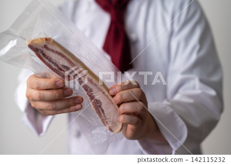 Chef with vacuum-packed bacon Chef with vacuum-packed bacon 142115232