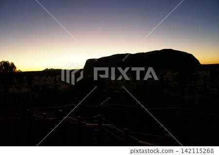 Silhouette of Uluru, viewed from a sunrise viewing area in Australia Silhouette of Uluru, viewed from a sunrise viewing area in Australia 142115268