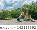Playground equipment with expansive clouds and colorful slides 142115392