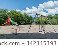 A playground under a summer blue sky and towering cumulonimbus clouds. 142115393