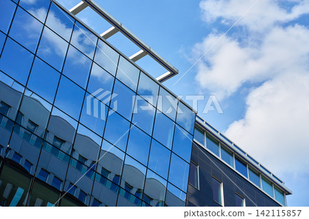 Modern office building with reflective glass windows Modern office building with reflective glass windows 142115857