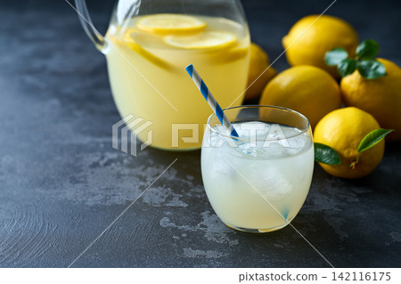 Refreshing homemade summer lemonade in glass with ice on a black table, selective focus. Cold refreshing lemonade . 142116175