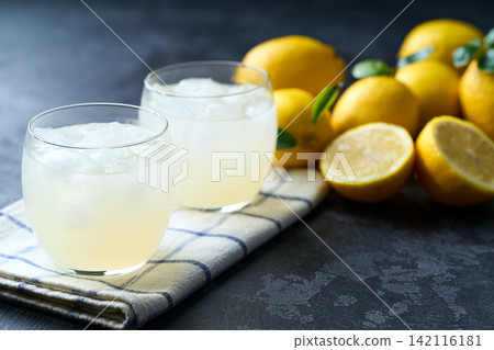 lemonade water with lemon slices , healthy and detox water drink with ice in summer on the dark kitchen table. 142116181