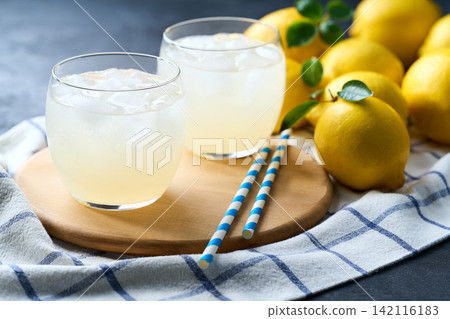 Freshly made lemonade with ice on dark table, selective focus, cold refreshing drink in summer . 142116183