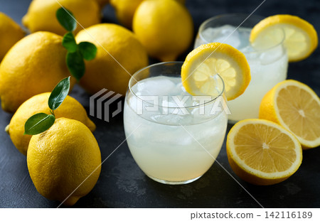 lemonade water with lemon slices , healthy and detox water drink with ice in summer on the dark kitchen table. lemonade water with lemon slices , healthy and detox water drink with ice in summer on the dark kitchen table. 142116189
