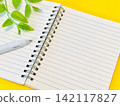 An open ring notebook and pen (yellow background) 142117827