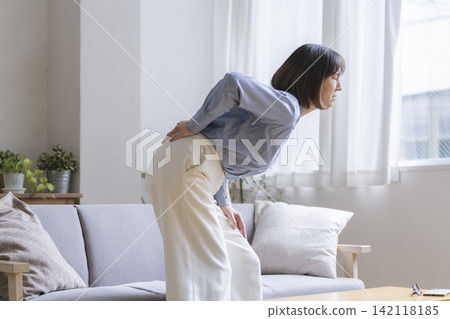 Image of lower back pain for a woman in her early 50s Image of lower back pain for a woman in her early 50s 142118185