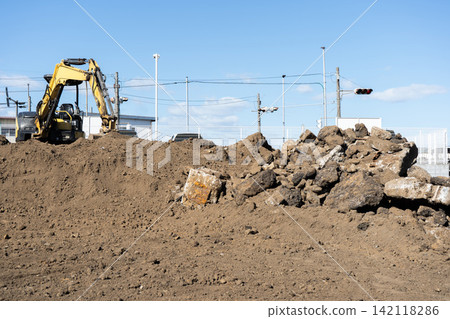 Concrete rubble and stones excavated from the vacant lot after the building was demolished. Concrete rubble and stones excavated from the vacant lot after the building was demolished. 142118286