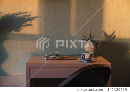 Cozy home office desk with coffee cup, notebook, potted plant and dramatic afternoon shadows on textured wall Cozy home office desk with coffee cup, notebook, potted plant and dramatic afternoon shadows on textured wall 142120839