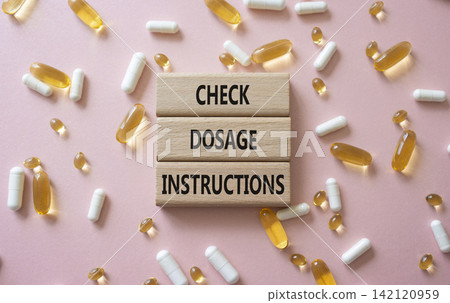 CHECK DOSAGE INSTRUCTIONS symbol. Concept words CHECK DOSAGE INSTRUCTIONS on wooden blocks. Beautiful pink background with pills. Healthcare and CHECK DOSAGE INSTRUCTIONS concept. Copy space. CHECK DOSAGE INSTRUCTIONS symbol. Concept words CHECK DOSAGE INSTRUCTIONS on wooden blocks. Beautiful pink background with pills. Healthcare and CHECK DOSAGE INSTRUCTIONS concept. Copy space. 142120959