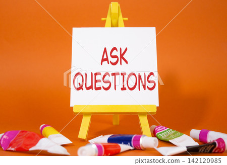 Ask Questions symbol. Wooden blocks with words Ask Questions. Beautiful orange background with paints and easel. Business and Ask Questions concept. Copy space. Ask Questions symbol. Wooden blocks with words Ask Questions. Beautiful orange background with paints and easel. Business and Ask Questions concept. Copy space. 142120985