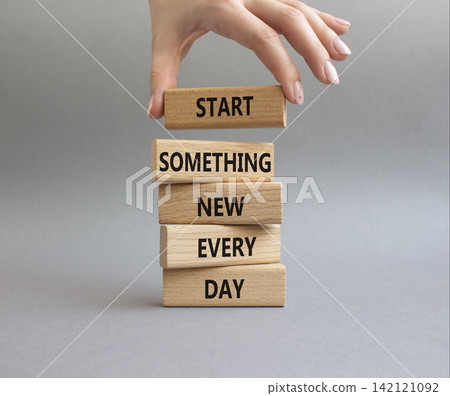 New symbol. Wooden blocks with words Start Something New Every Day. Businessman hand. Beautiful grey background. Business and New concept. Copy space New symbol. Wooden blocks with words Start Something New Every Day. Businessman hand. Beautiful grey background. Business and New concept. Copy space 142121092