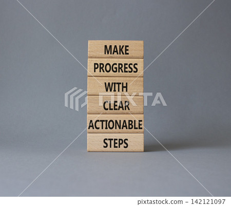 Make progress with clear actionable steps symbol. Concept words make progress with clear actionable steps on wooden blocks. Businessman hand. Beautiful white background. Business concept. Copy space. Make progress with clear actionable steps symbol. Concept words make progress with clear actionable steps on wooden blocks. Businessman hand. Beautiful white background. Business concept. Copy space. 142121097