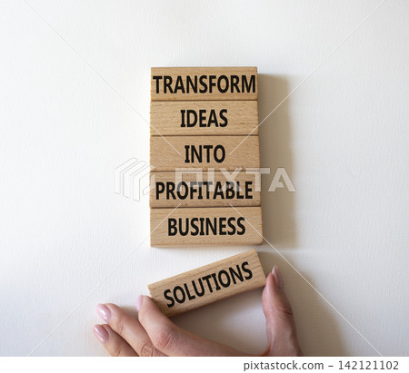 Transform ideas into profitable business solutions symbol. Concept words transform ideas into profitable business solutions on wooden blocks. Businessman hand. Beautiful white background. Business Transform ideas into profitable business solutions symbol. Concept words transform ideas into profitable business solutions on wooden blocks. Businessman hand. Beautiful white background. Business 142121102