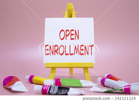 Open Enrollment symbol. Wooden blocks with words Open Enrollment. Beautiful pink background with paints and easel. Business and Open Enrollment concept. Copy space. Open Enrollment symbol. Wooden blocks with words Open Enrollment. Beautiful pink background with paints and easel. Business and Open Enrollment concept. Copy space. 142121124