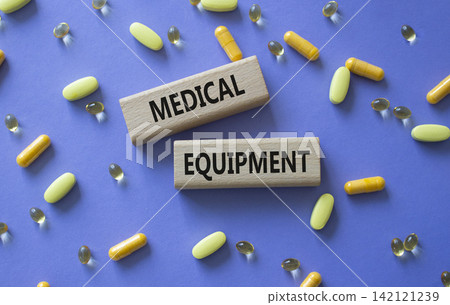 MEDICAL EQUIPMENT symbol. Concept word MEDICAL EQUIPMENT on wooden blocks. Beautiful purple background with pills. Medicine and MEDICAL EQUIPMENT. Copy space MEDICAL EQUIPMENT symbol. Concept word MEDICAL EQUIPMENT on wooden blocks. Beautiful purple background with pills. Medicine and MEDICAL EQUIPMENT. Copy space 142121239