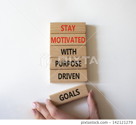 Stay motivated with purpose driven goals symbol. Concept words stay motivated with purpose driven goals on wooden blocks. Businessman hand. Beautiful grey background. Business concept. Copy space. Stay motivated with purpose driven goals symbol. Concept words stay motivated with purpose driven goals on wooden blocks. Businessman hand. Beautiful grey background. Business concept. Copy space. 142121279