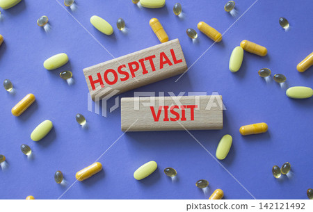 HOSPITAL VISIT symbol. Concept word HOSPITAL VISIT on wooden blocks. Beautiful purple background with pills. Medicine and HOSPITAL VISIT. Copy space HOSPITAL VISIT symbol. Concept word HOSPITAL VISIT on wooden blocks. Beautiful purple background with pills. Medicine and HOSPITAL VISIT. Copy space 142121492