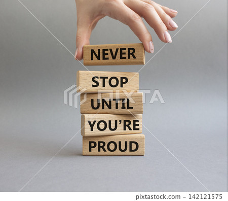Never Stop symbol. Wooden blocks with words Never Stop Until You are Proud. Businessman hand. Beautiful grey background. Business and Never Stop concept. Copy space Never Stop symbol. Wooden blocks with words Never Stop Until You are Proud. Businessman hand. Beautiful grey background. Business and Never Stop concept. Copy space 142121575