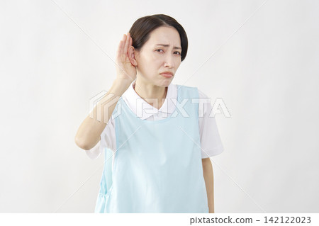 一位女護理員手撫耳朵，背景為白色。 142122023